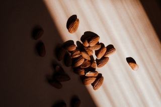 Amandes, graines de courge et chocolat noir disposés sur une planche en bois